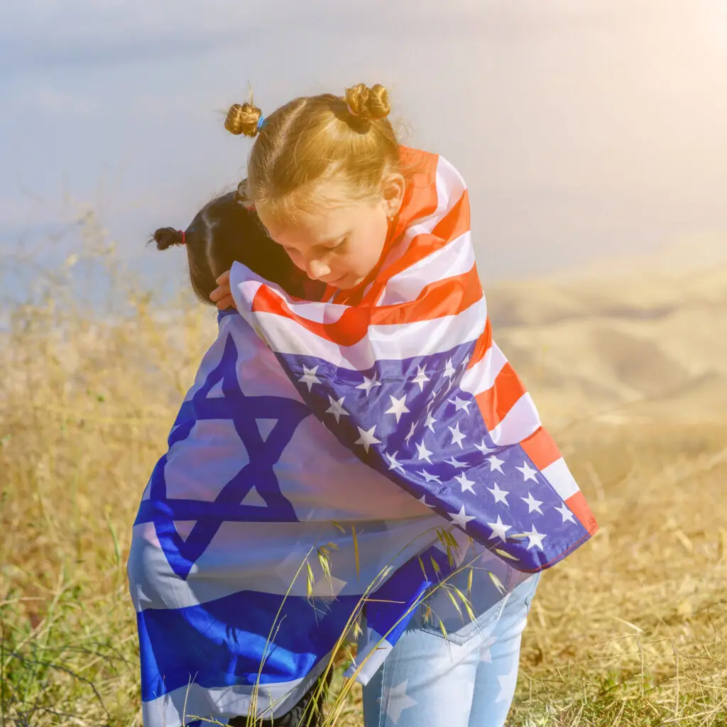 girls hugging wearing american and israeli flags